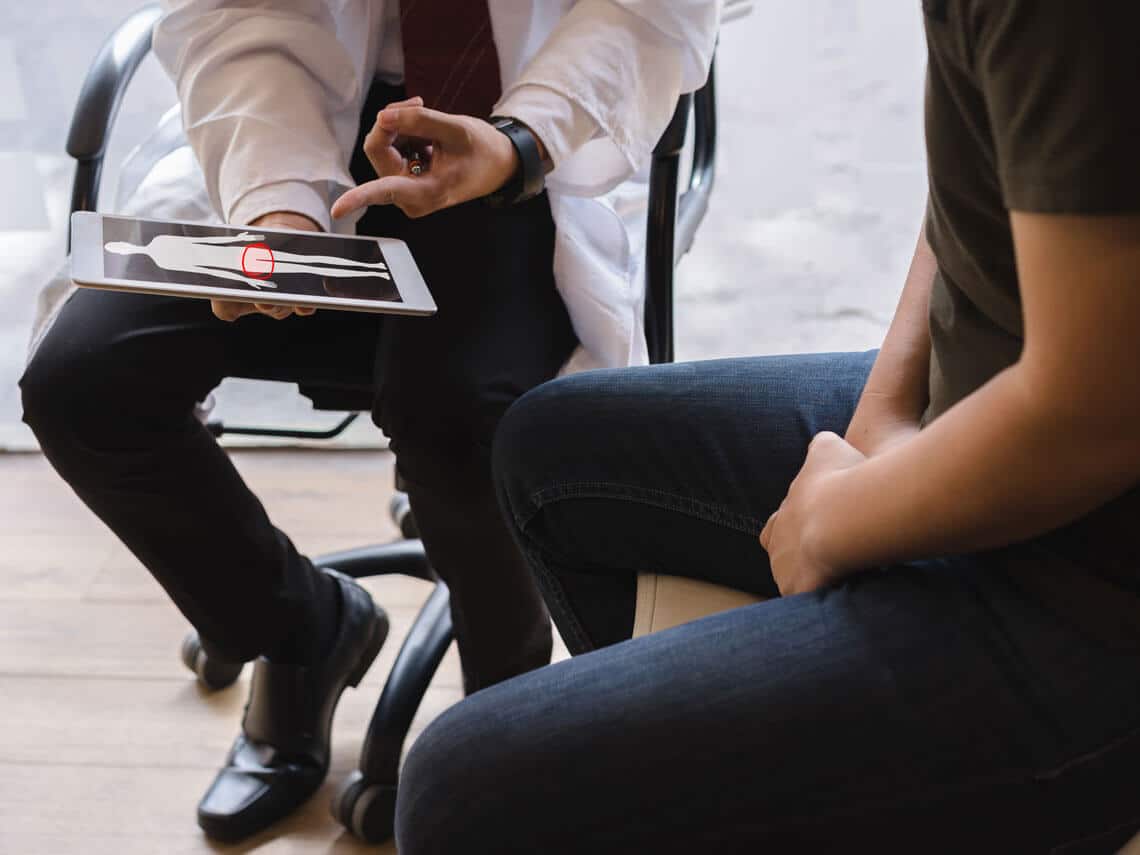 doctor showing man prostate location on image
